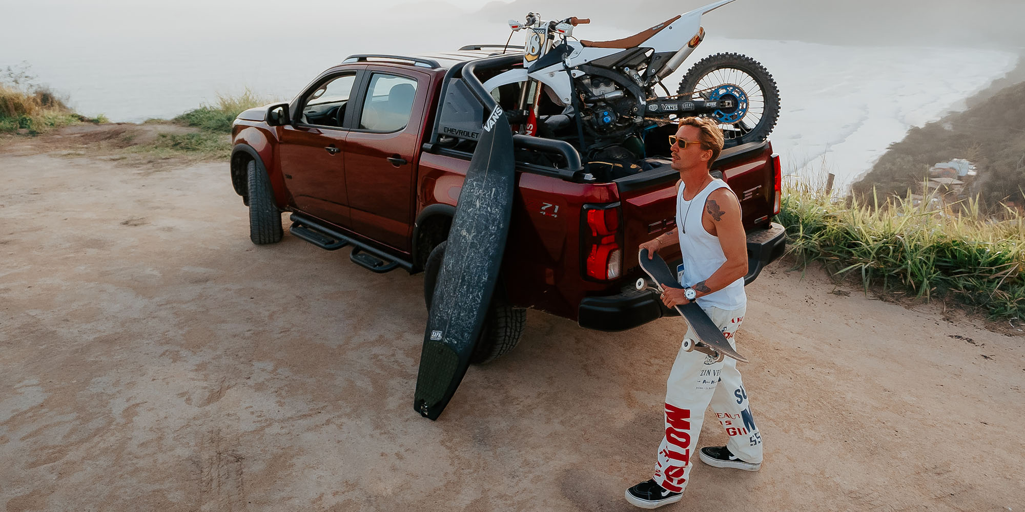 Chevrolet S10 Z71 transportando una motocicleta todoterreno y una tabla de surf en la platina, demostrando su capacidad de carga.